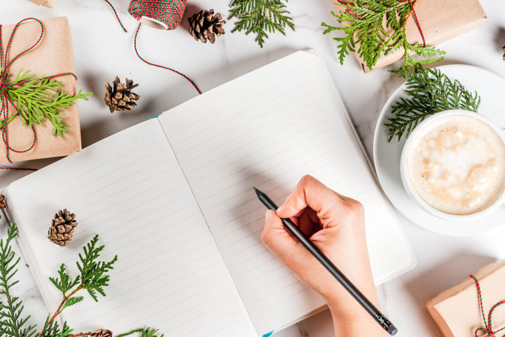 Woman writing in Christmas journal