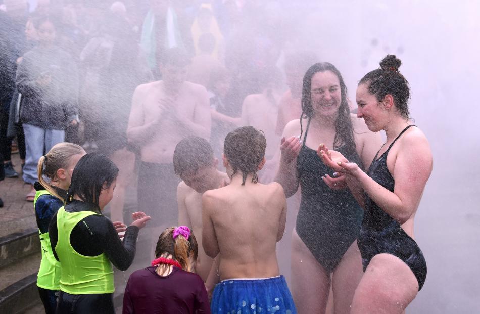 People warm up in sprayed warm water after their dip.